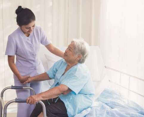 caregiver assiting elder woman in using a walker concept